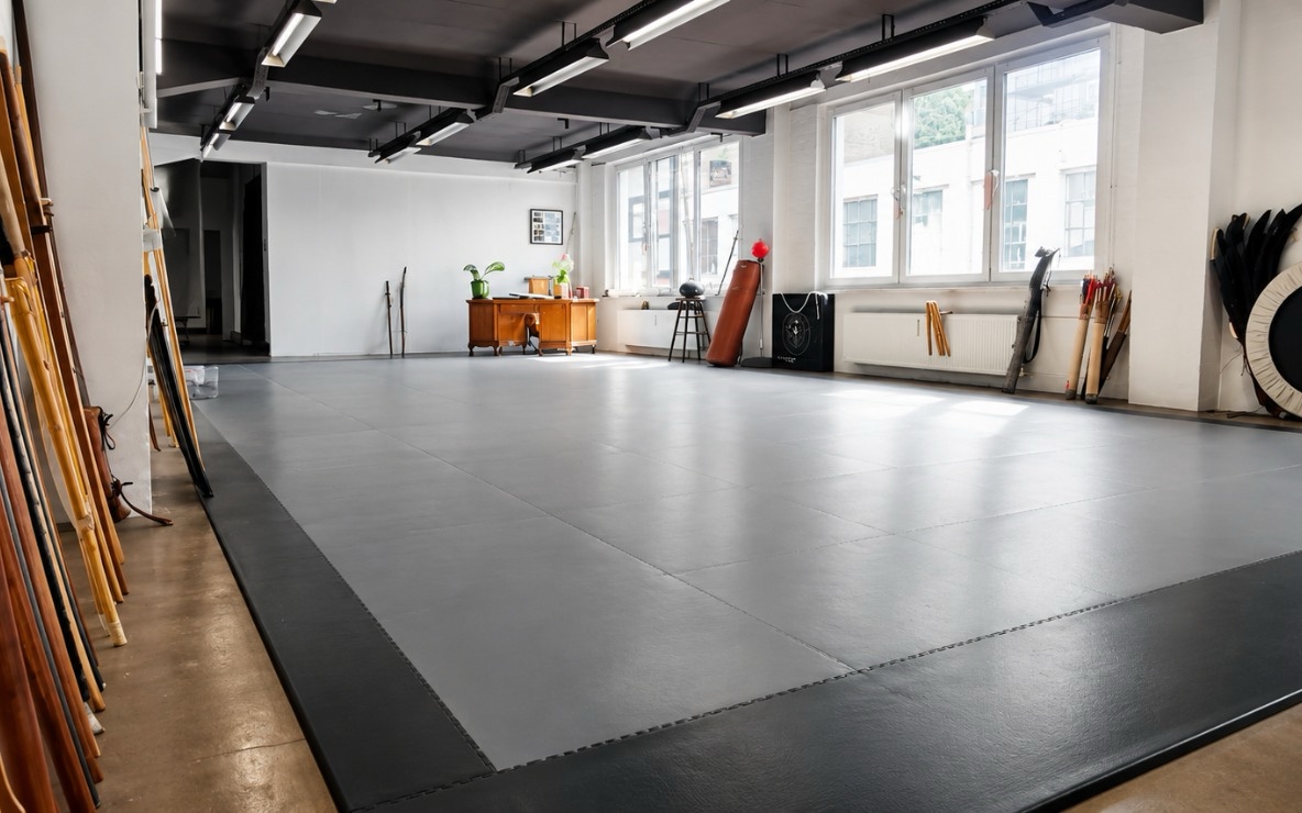 Heller Pa-Kua Trainingsraum mit Mattenfläche und traditionellen Trainingswaffen in Hamburg
